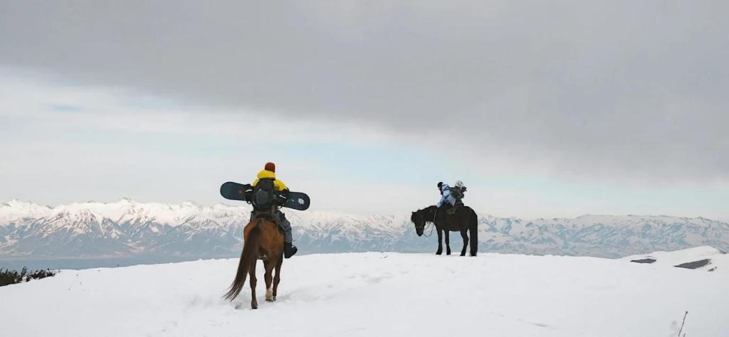 People riding horses in the mountains of Kyrgyzstan